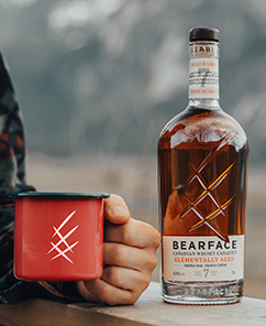 Man drinking Bearface whisky in a mug